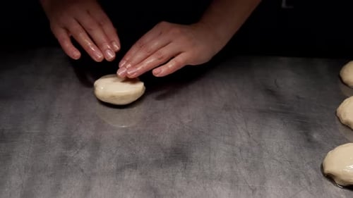 Hands Preparing Dough on Metal Surface