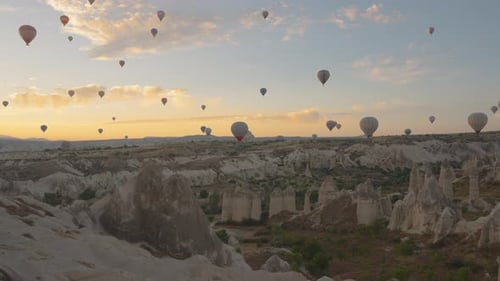 Hot Air Balloons at Sunrise over Desert Landscape