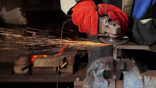 A Closeup of a Man Who Cuts Metal in a Forge Production of Metal Structures