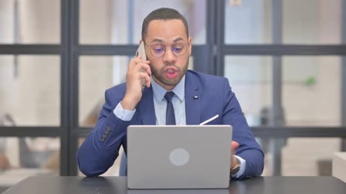Professional Man Talking on Mobile Phone at Desk