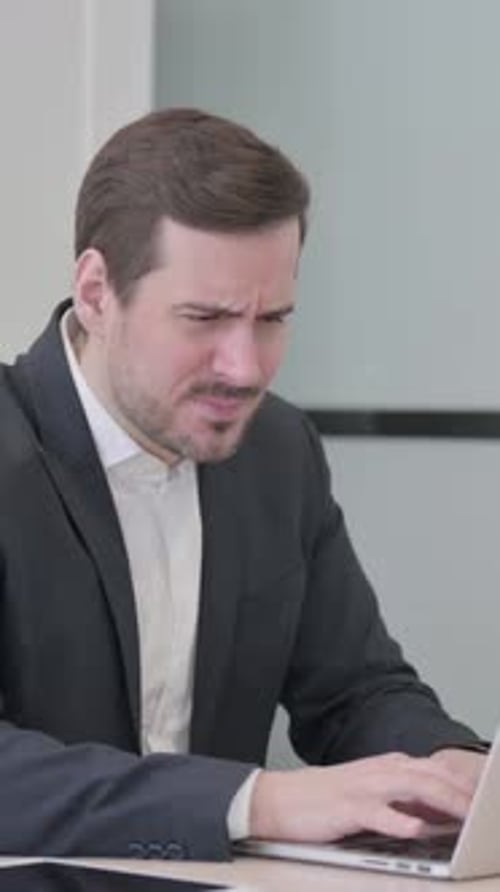 Businessman Reacting to Loss While Working in Office, vertical video