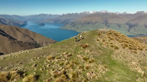 Couple reaching Isthmus Peak Summit with stunning view of Southern Alps, New Zealand