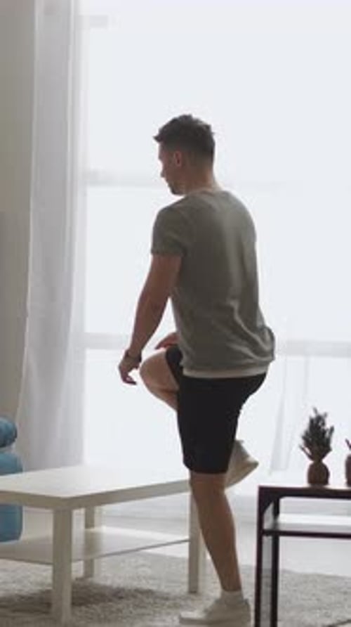 Man Performing Step-Ups on Coffee Table for Home Workout