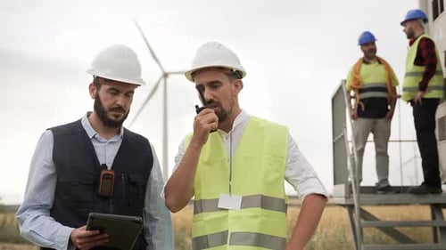Team of Electrical Technicians and Engineers Working in Wind Turbine Electricity Power Station