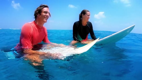 Happy Surfers Relaxing on Surfboard in Tropical Ocean