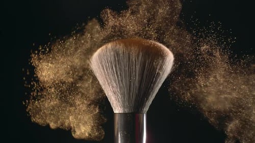 Superzeitlupen-Makroaufnahme von Make-up-Pinsel und goldglänzendem Gesichtspudershake mit 1000 Bildern pro Sekunde, elegant