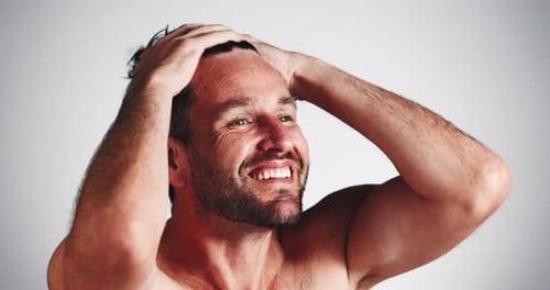 Clean, man and smile with wet hair in studio for shampoo shine, morning routine and grooming