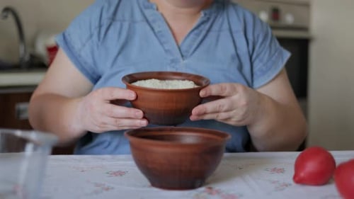 Woman Prepares Rice Grains in a Kitchen