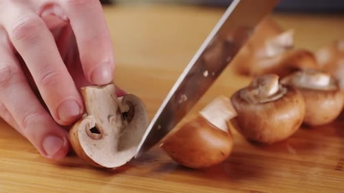 Chef Cutting the Mushrooms on a Wooden Board with Knife Mushroom Cooking Close Up