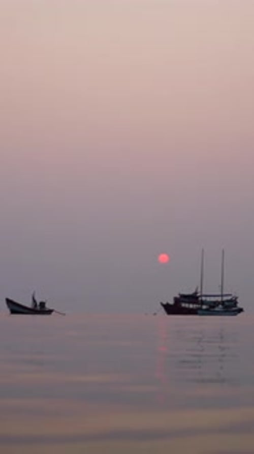 View From the Sea of Boats in the Background of a Sunset