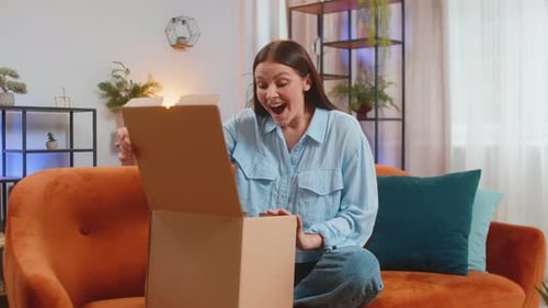 Happy Woman Girl Shopper Unpacking Cardboard Box Delivery Parcel Online Shopping Purchase at Home