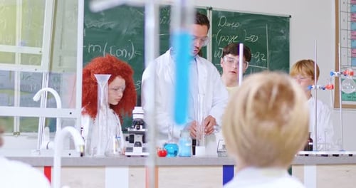 Lesson of Chemistry at School Concept Caucasian Male Teacher Showing Chemical Experiment to Teens
