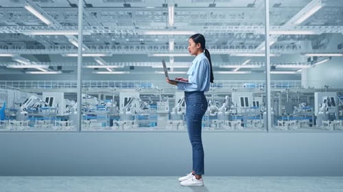 Asia Female Professional Work On Laptop And Look Around at Factory Digitalization
