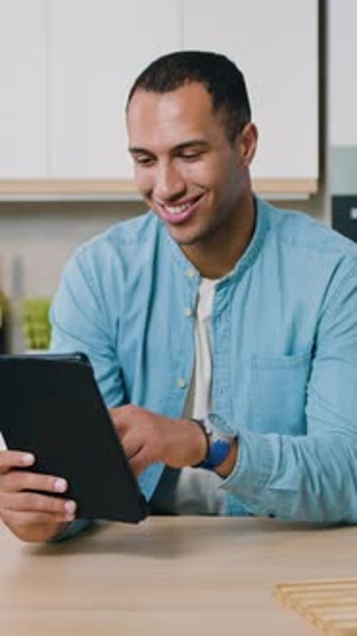 Smiling Man Using Tablet in Bright Modern Kitchen