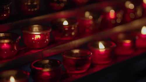 Flickering Votive Candles Glow in the Darkness