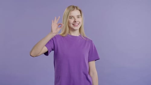 Smiling Woman Makes Okay Gesture in Studio