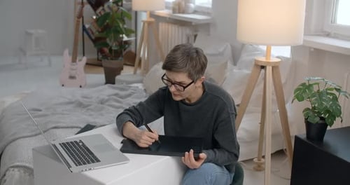 Woman Drawing Digitally on Tablet Device at Home