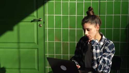 Beautiful Young Woman Sitting at Table with Laptop in Cafe Working Online Typing and Smiling