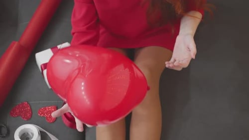 Woman Wraps Valentine Gift with Heart Balloon