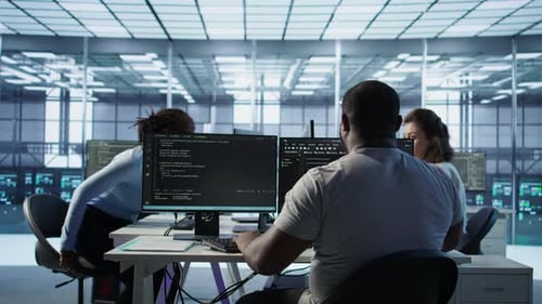 Developer Typing Code on PC to Mend Data Center Racks