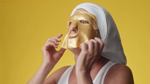 Middle-aged Woman Using Collagen Golden Facial Mask
