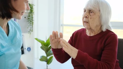 Senior Woman Talks With Attentive Health Care Worker