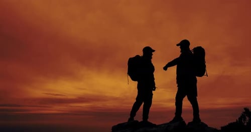 Hikers Silhouette on Mountain at Colorful Sunrise