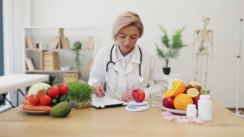 Female Doctor Weighing Apple, Writing Diet Plan