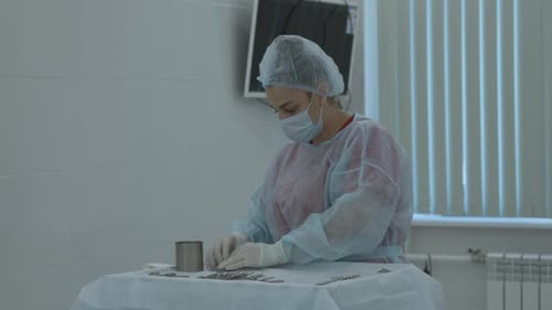 Mehrere Operationswerkzeuge auf dem Tisch im Operationssaal, Krankenschwester in Gummihandschuhen