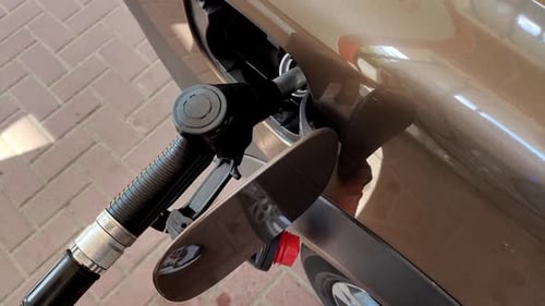 Close View of the Gas Nozzle in the Gas Tank of a Brown Car The Process of Refueling a Car with