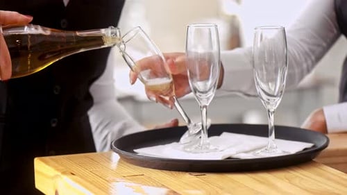 Staff Waiter Holding Glasses, While Champagne Being Pored Into Glasses