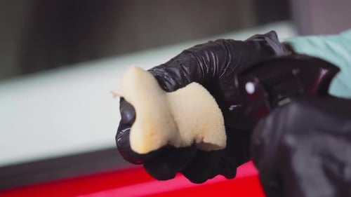 Spraying Cleaner on Sponge With Gloved Hand