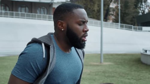 Portrait of Tired Afro Jogger Running on Spot at Stadium in Slow