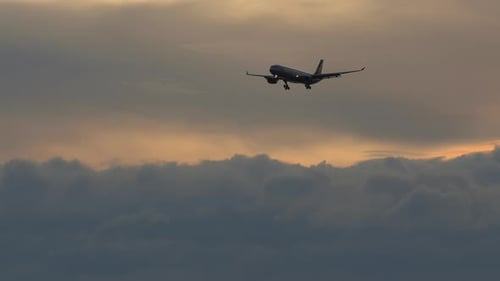 Flugzeug-Silhouette bei bewölktem Sonnenuntergang