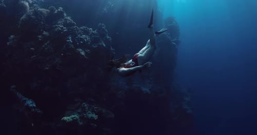 Woman Freediver Dives and Swims Undersea in Tropical Sea with Sun Rays Free Diving in Deep Blue Sea