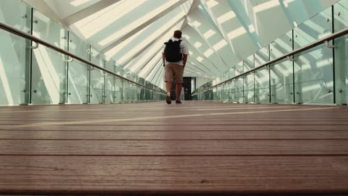 Tourist walking through modern bridge