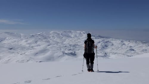 Hiker in Snow Mountains on Sunny Day