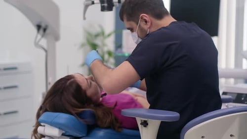 Dental Healthcare Professional Checking Teeth of Female Patient in Contemporary Clinic Dental Tools