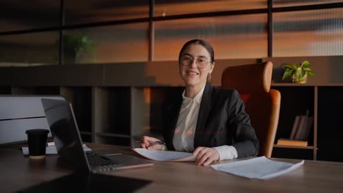 Business Woman Smiling at Desk in Modern Office