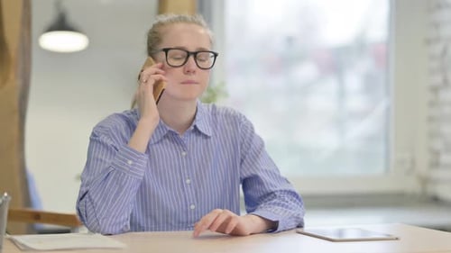 Woman Speaking on Phone at Indoor Workspace