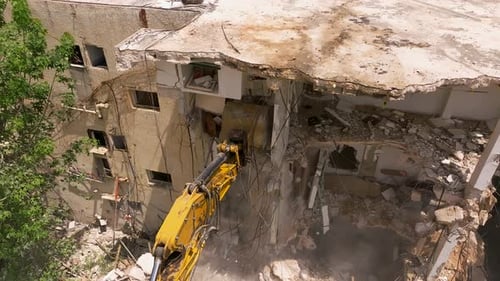 Excavator arm demolishing an old building, Aerial view