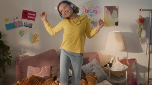 Happy Girl Dancing in Bedroom with Headphones