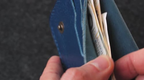 A Closeup View of Cash Being Stored in a Blue Wallet for Financial Purposes