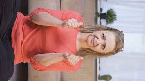 Smiling Woman Gives Two Thumbs Up Indoors