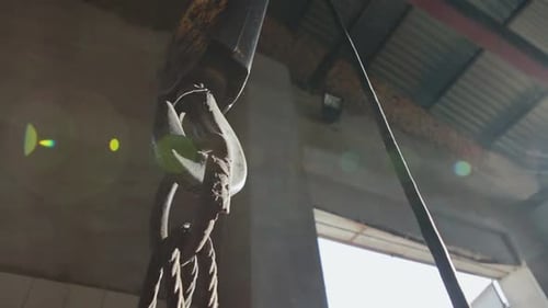 Metallic Industrial Hook for Lifting Heavy Things in the Factory in the Movement of the Sun's Rays