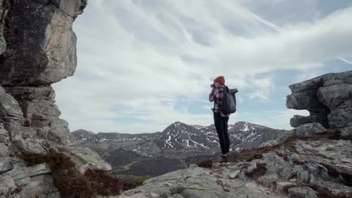 Female taking pictures of the high mountains in the nature of Spain. Wide shot