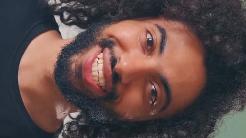 Young Happy Arabian Man Looks at Camera and Smiles Stands on Gray Background