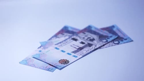 Counting Saudi Riyal Banknotes on Table