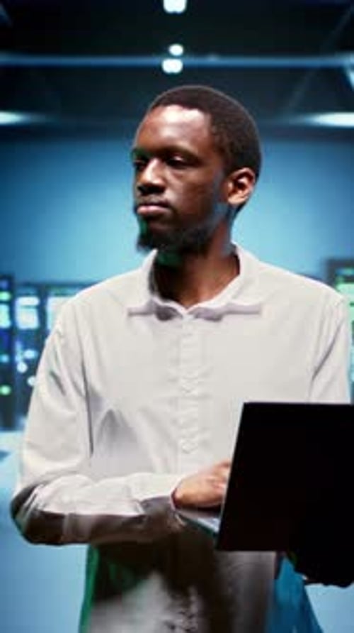 Man Working with Laptop in Data Server Room