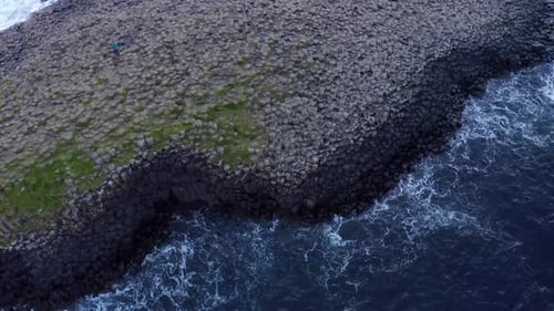 Slow-motion aerial of Giant's Causeway with rotating top-down view